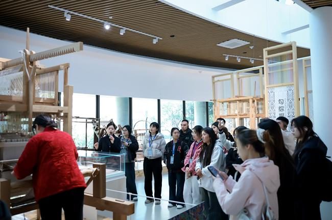 师傅演示传统织机技艺，学生围观，浙阿非遗研学实拍
