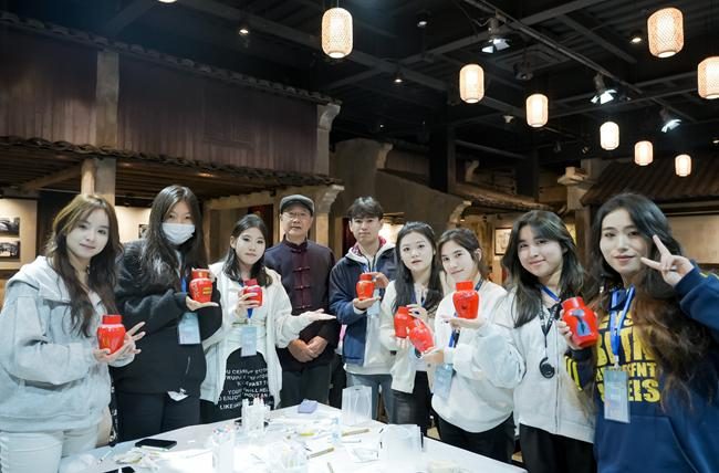 学生捧手工作品在古建内合影，浙阿非遗研学实拍