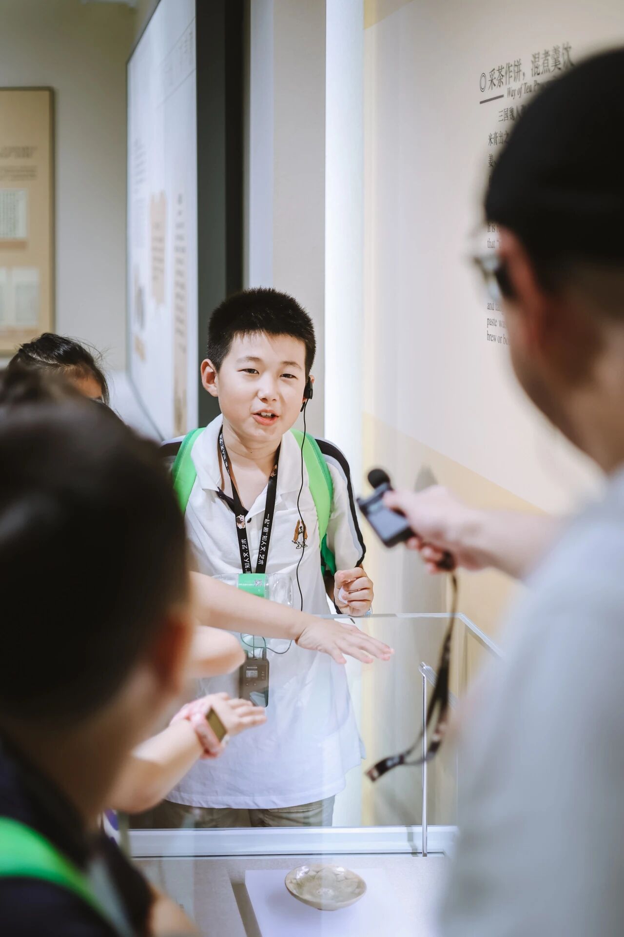 背书包的小男孩接受手持麦克风采访，浸思研学学员分享实拍