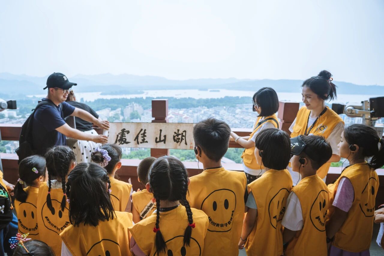 穿黄背心的孩子在户外观景台跟随导游参观，浸思研学户外走读课程