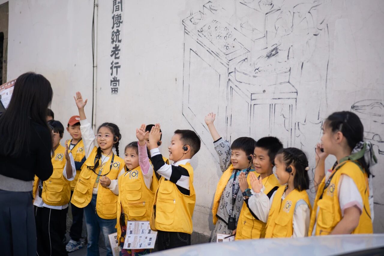 穿黄色背心的学生听讲解员介绍壁画内容，浸思研学博物馆课堂实拍