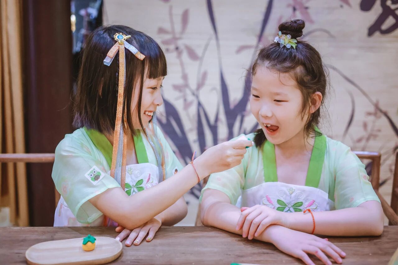 两个穿汉服的小女孩开心互动，浸思研学传统文化体验实拍