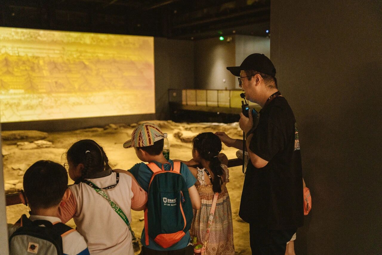 讲解员向儿童介绍展品和模拟考古现场，浸思研学互动教学实拍