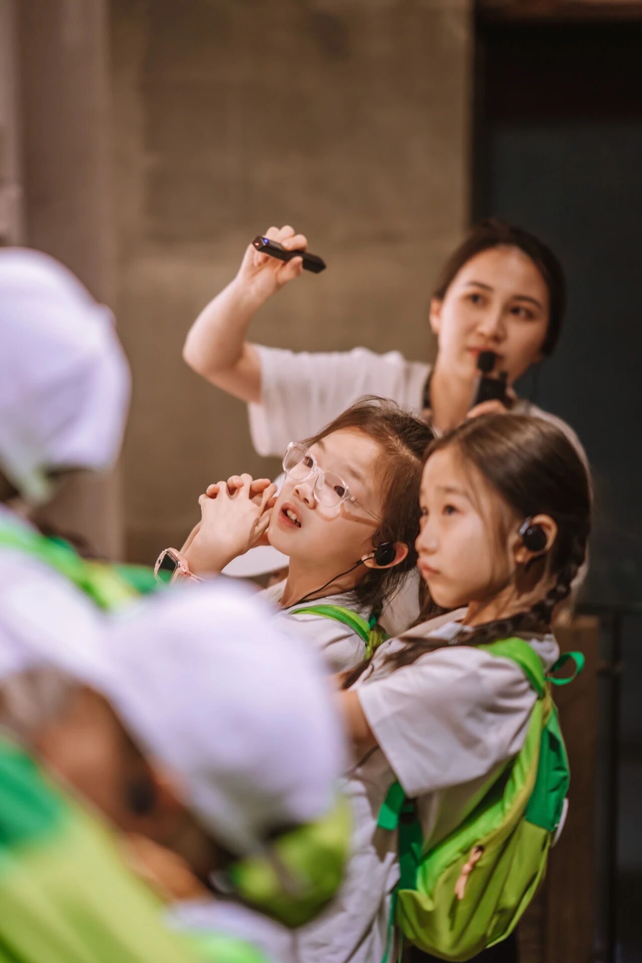 两名穿校服的小女孩聚精会神听讲举麦互动，浸思研学课堂实拍