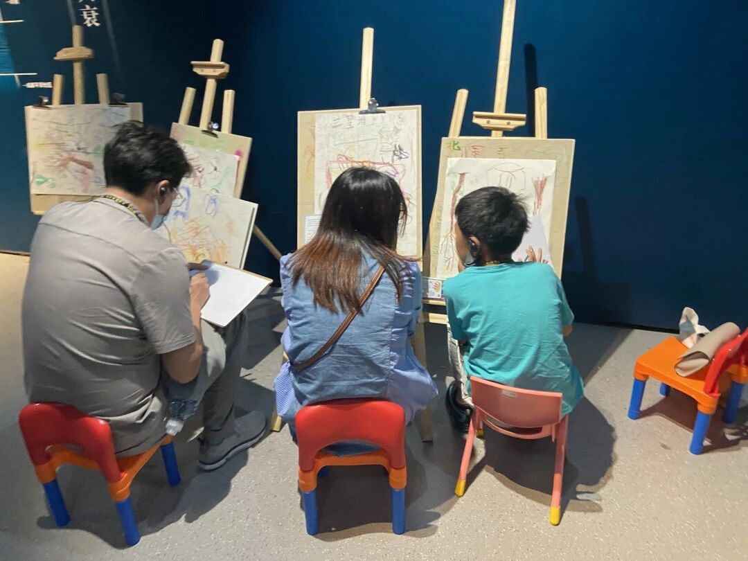 三人在室内画架前专注绘画欣赏画作，浸思研学艺术课堂实拍