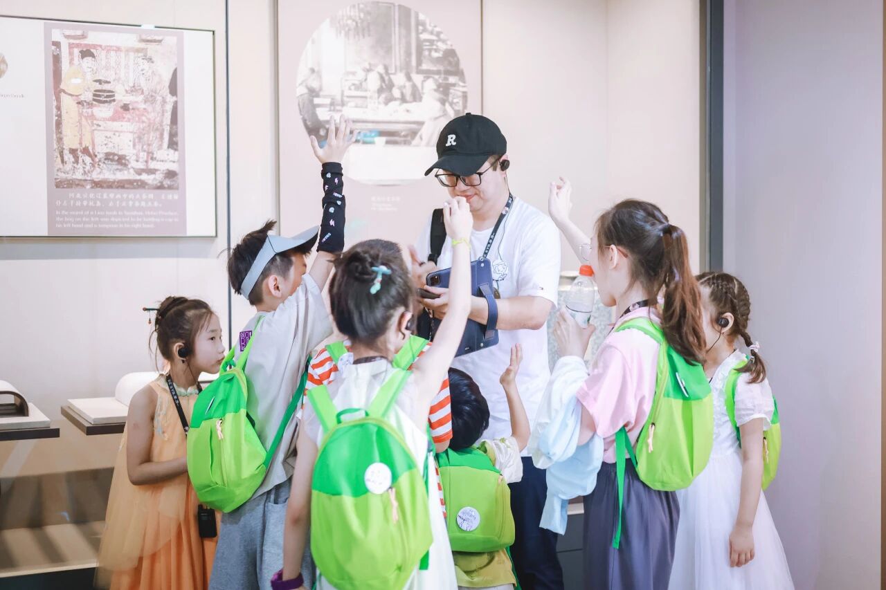 讲解员给背绿书包的小学生进行参观讲解互动问答，浸思研学导师讲解实拍