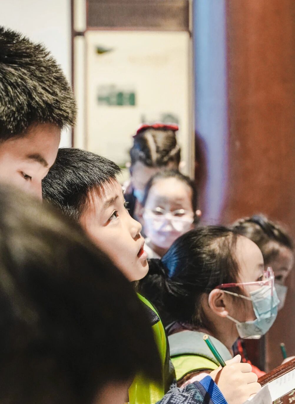 一群学生在教室内认真听讲的侧写镜头，浸思研学课堂实拍